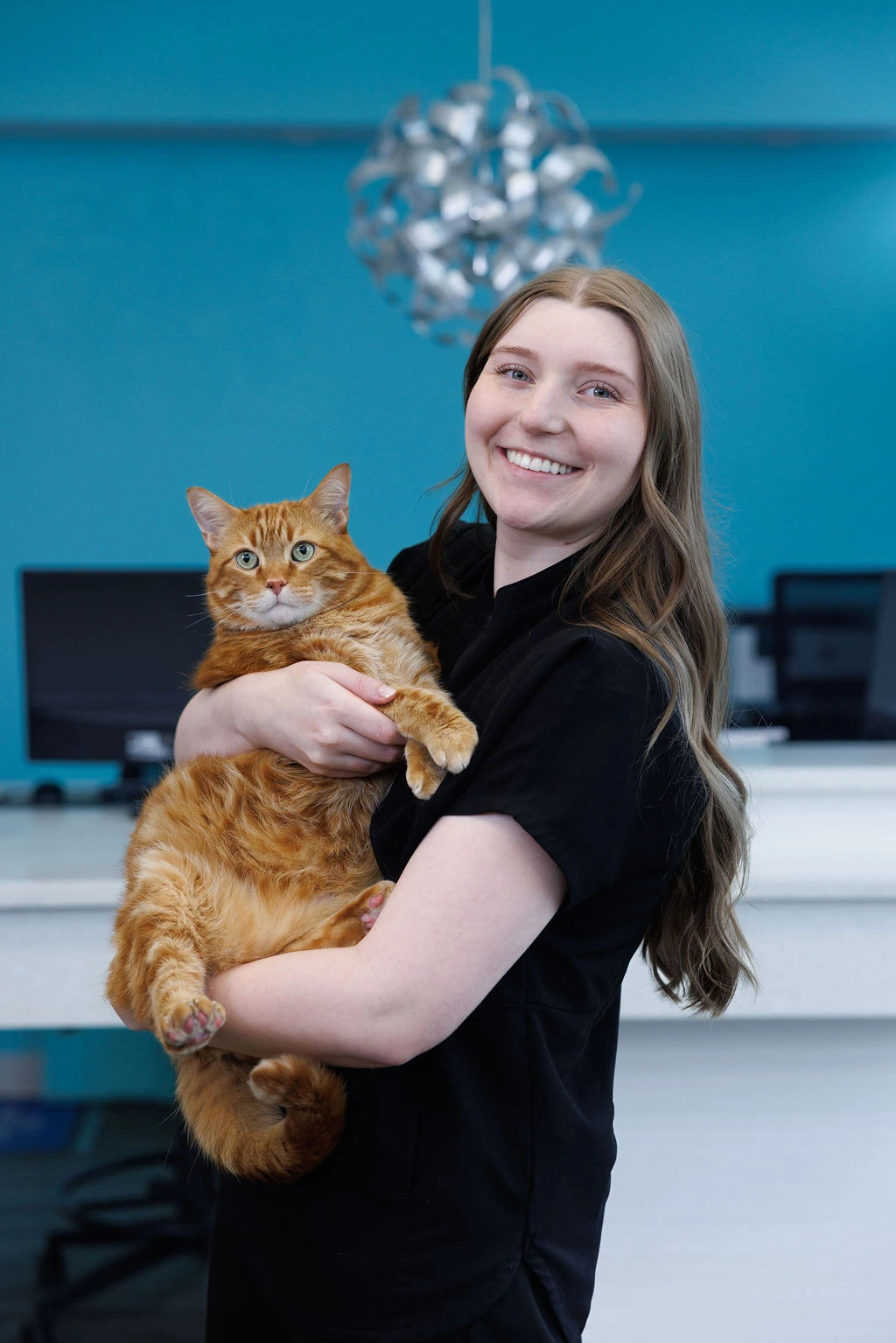 Jaime holding a large orange tabby cat